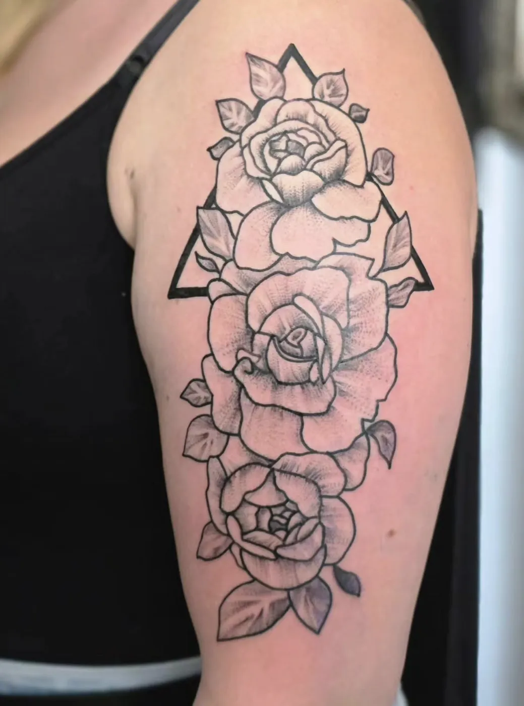 Rosen mit geometrischem Dreieck als Dotwork-Linework-Tattoo am Oberarm.
